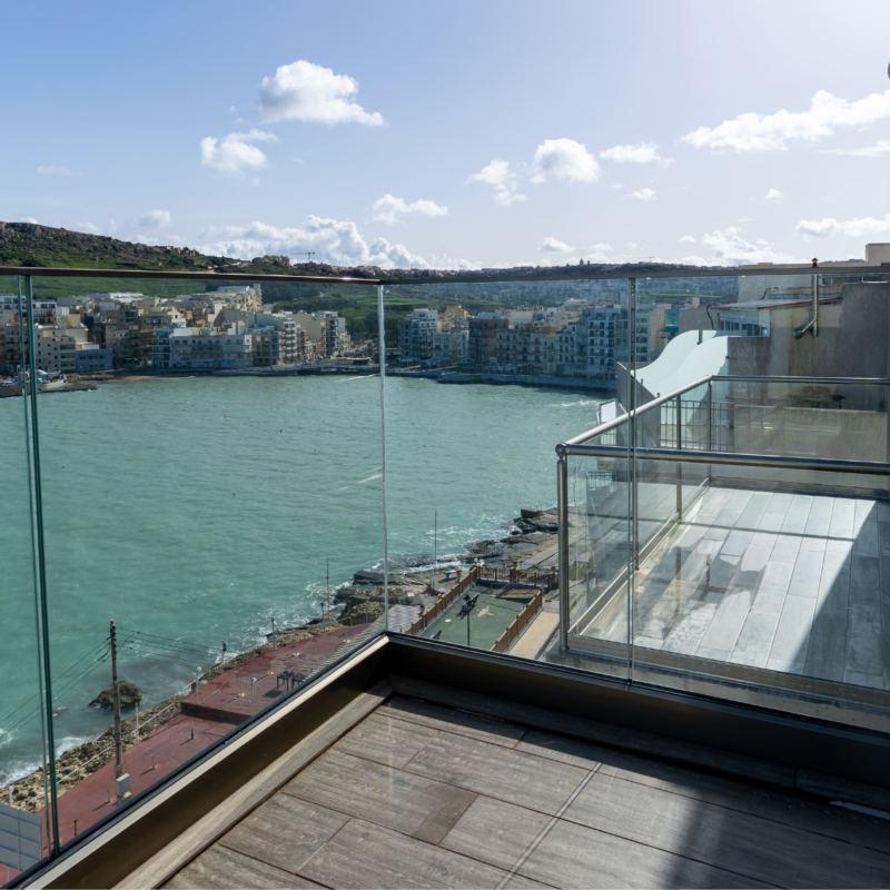 Modern balcony overlooking Marsalforn bay at Elzan apartment in Gozo