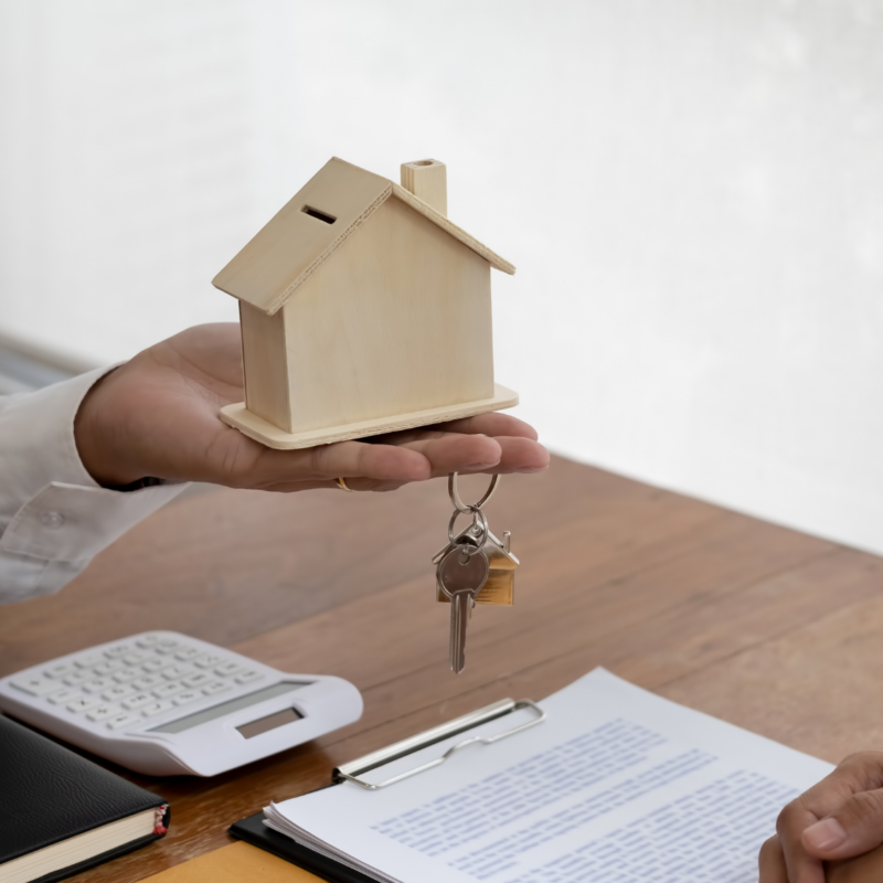 House keys and model home beside property documents.